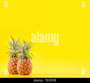 Bella di ananas fresco isolato su colore giallo brillante background, estate frutta di stagione idea design pattern concetto, spazio copia, close up Foto Stock