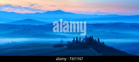 Atmosfera di mattina in Toscana paesaggio collinare con nebbia all alba, Country house Belvedere, Val d'Orcia, Toscana, Italia Foto Stock