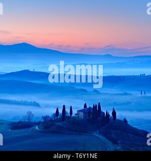 Atmosfera di mattina in Toscana paesaggio collinare con nebbia all alba, Country house Belvedere, Val d'Orcia, Toscana, Italia Foto Stock