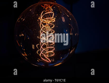 Una riproduzione vintage Edison globe lampadina con un filamento a forma di spirale è raffigurato, Sett. 6, 2017, a Campesino coffee shop in Houston, Texas. Foto Stock