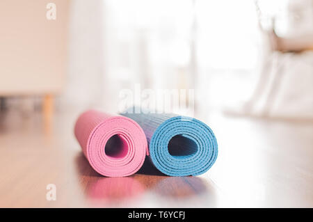 Materassini da yoga e manubri sul pavimento in legno. Uno stile di vita sano concetto Foto Stock
