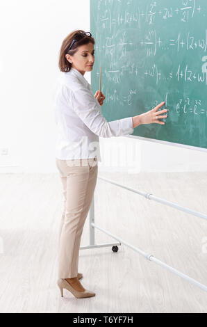 Femmina insegnante di matematica di fronte alla lavagna Foto Stock