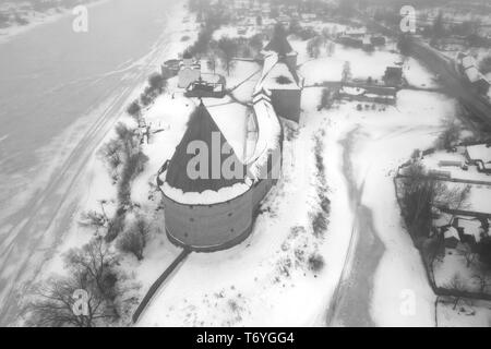 Una vista dall'altezza dell'Staraya Ladoga fortezza su una nebbiosa giornata invernale (fotografia aerea). Regione di Leningrado, Russia Foto Stock