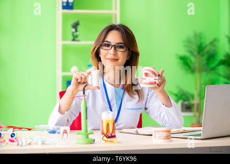 Donna dentista lavora sui denti impianto Foto Stock