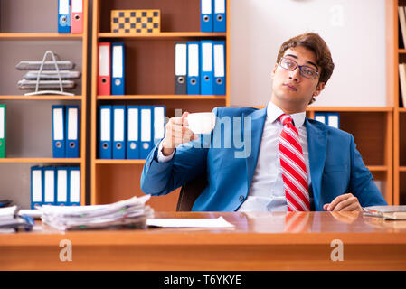 Giovane uomo politico bello seduto in ufficio Foto Stock