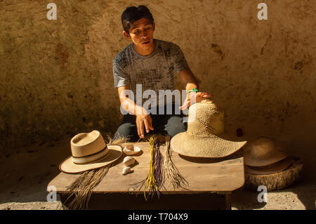 Tour guida al Becal Museo del cappello che spiega il tradizionale Maya hat processi decisionali dall'area. I cappelli sono realizzati all'interno di un umido la grotta fresca. Foto Stock