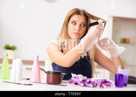 Giovane donna con arricciacapelli in Barberia Foto Stock