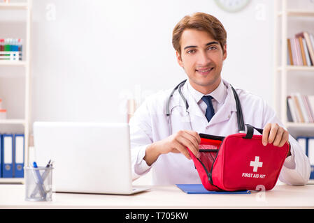 Giovane medico con kit di primo soccorso in ospedale Foto Stock