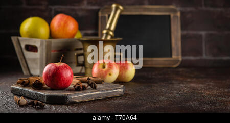 Fresche mele rosse con bastoncini di cannella Foto Stock