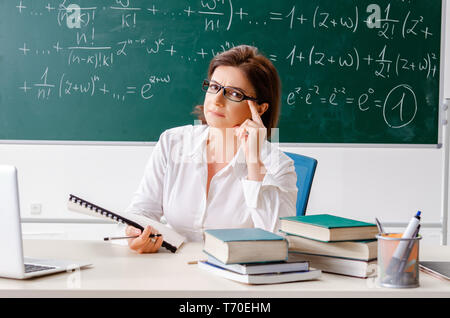 Femmina insegnante di matematica di fronte alla lavagna Foto Stock