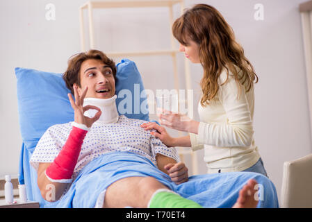 Amorevole moglie guardando dopo aver ferito il marito in ospedale Foto Stock