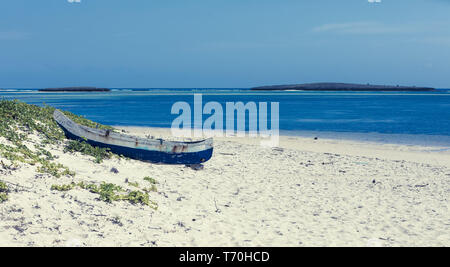 Barca abbandonata in spiaggia sabbiosa in Madagascar Foto Stock