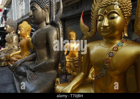 Statue di Buddha al di fuori di una fabbrica per la produzione di oggetti religiosi in Bamrung Muang Road, Bangkok, Thailandia Foto Stock