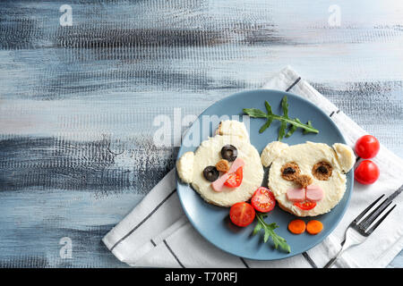 Piastra con toast creativo per bambini sul tavolo di legno, vista dall'alto Foto Stock