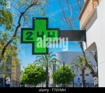 Green medical ventiquattro ore di farmacia cartello al giorno. Farmacia 24 ore aperte in Murcia, Spagna, 2019. Green Cross segno della farmacia Farmaceutico. Foto Stock