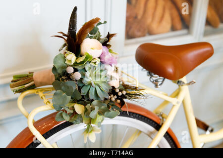 Bici retrò con un bel bouquet sul tronco Foto Stock