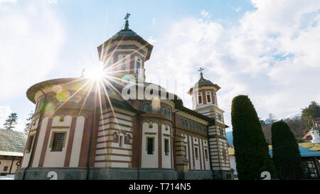 Sinaia, Romania - Marzo 09, 2019: vista del Monastero di Sinaia con vera sun lens flare situato in Sinaia, contea di Prahova, Romania. Foto Stock