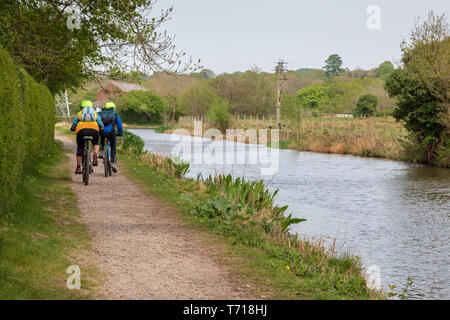 Un paio in mountain bike lungo un canale alzaia. I ciclisti sono persone di mezza età. Foto Stock