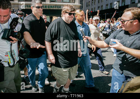 Documentarista e autore Michael Moore è scortato da guardie del corpo mentre partecipavo a una marcia di protesta durante la Convention Nazionale Repubblicana a New York. A sinistra di Moore, Shock Jock e teorico del complotto Alex Jones è il tentativo di intervista Moore. Foto Stock