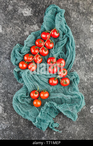 Freschi pomodori ciliegia su uno sfondo nero. Foto Stock