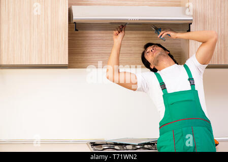 Giovane imprenditore riparazione aria condizionata in cucina Foto Stock