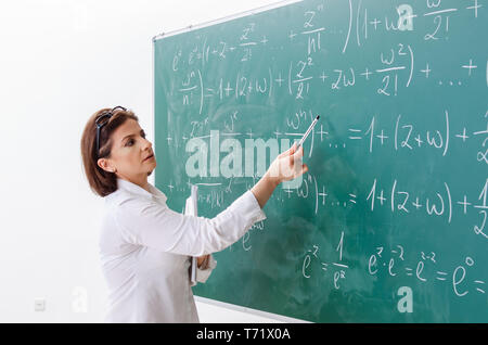 Femmina insegnante di matematica di fronte alla lavagna Foto Stock