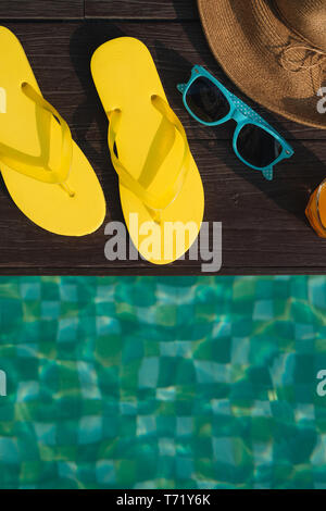 Cappello, occhiali da sole e ciabatte da piscina Foto Stock