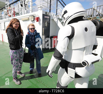 I passeggeri soddisfino un membro della legione 501Irlanda Garrison sul Lough Foyle Ferry, voce al Maggio 4 Festival a Malin Head dove le scene di Star Wars ultimi Jedi dove girato. Foto Stock