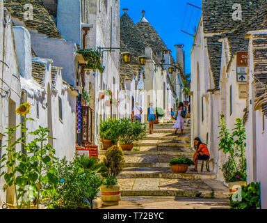 Pittoresca strada in Alberobello, Puglia, Italia Foto Stock