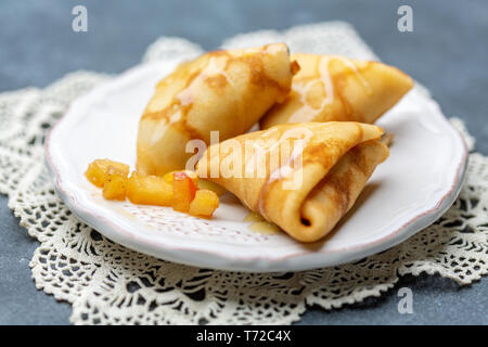 Crepes a forma di triangoli ripieno di mele. Foto Stock