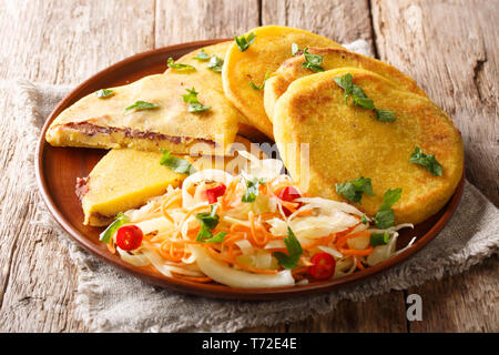 Gustose pietanze per vegetariani pupusas ricetta servita con curtido closeup su una piastra sul tavolo orizzontale. Foto Stock