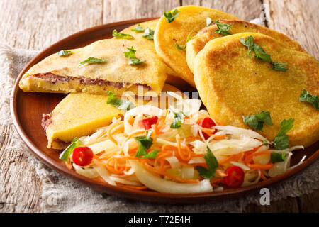 Deliziosi piatti vegetariani Pupusas fritte servite con coleslaw close-up su una piastra sul tavolo orizzontale. Foto Stock