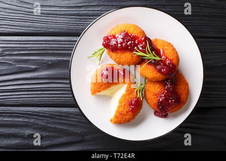 Cotta camembert fritto con salsa di mirtilli close-up su una piastra sul tavolo. parte superiore orizzontale vista da sopra Foto Stock