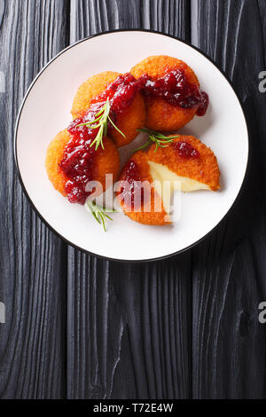 Cotta camembert fritto con salsa di mirtilli close-up su una piastra sul tavolo. Verticale in alto vista da sopra Foto Stock