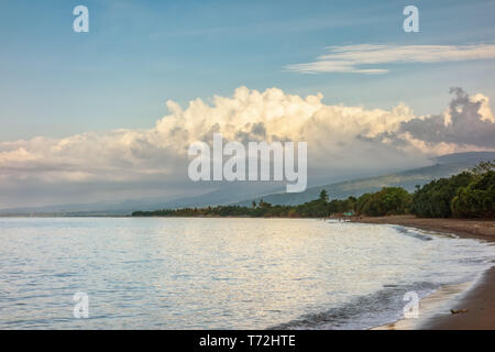 Una sabbia scura Beach a nord di Bali Indonesia Foto Stock