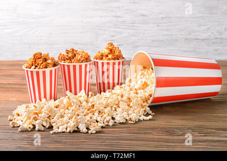 Tazze con gustosi popcorn sul tavolo di legno Foto Stock