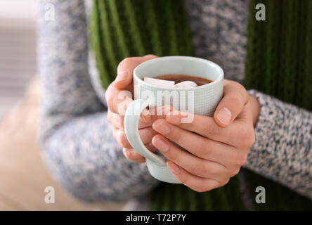 Donna che mantiene tazza di cioccolata calda con marshmallow, primo piano Foto Stock