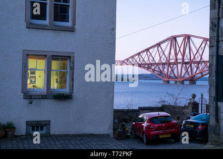 Vista serale di una casa a South Queensferry e Ponte di Forth Rail sul Firth of Forth, nei pressi di Edimburgo, Scozia Foto Stock