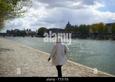 Donna anziana godendo di una passeggiata lungo il fiume Senna in estate il sole in Parigi Foto Stock