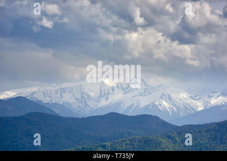 Thunderclouds oltre innevate montagne rocciose Foto Stock