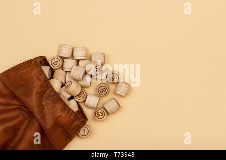 Lotto in legno Barili con borsa di stoffa su sfondo beige. Gioco di bordo del lotto. Vista da sopra con copia spazio. Foto Stock