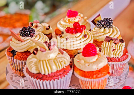 Deliziosamente disposti muffin con ripieno di panna e guarnita con frutta in un buffet di nozze Foto Stock