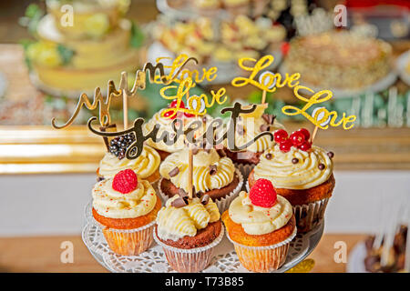 Deliziosamente disposti muffin con ripieno di panna e guarnita con frutta in un buffet di nozze Foto Stock