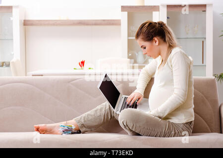 Giovane donna incinta nella pianificazione del bilancio concept Foto Stock