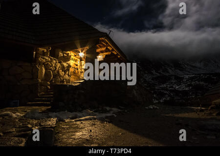 La fotografia notturna di una baita di montagna vicino a cinque laghi della Valle di Tatra, Polonia (Schronisko Pięć Stawów), Polonia Foto Stock