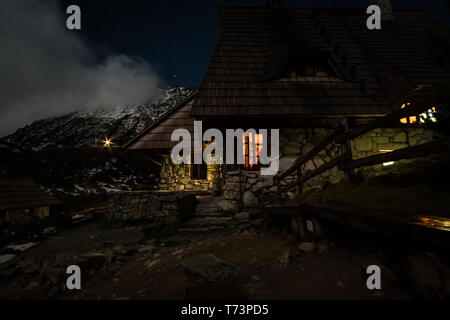 La fotografia notturna di una baita di montagna vicino a cinque laghi della Valle di Tatra, Polonia (Schronisko Pięć Stawów), Polonia Foto Stock