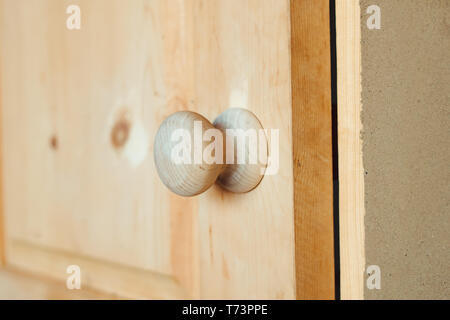 Round manico in legno su un bianco porta in legno Foto Stock