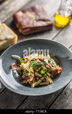 Pasta casarecce con pancetta pancetta parmigiano e basilico erbe. Italiano o cucina mediterranea. Foto Stock