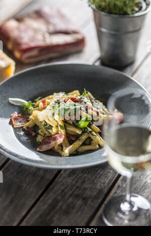 Pasta casarecce con pancetta pancetta parmigiano e basilico erbe. Italiano o cucina mediterranea. Foto Stock