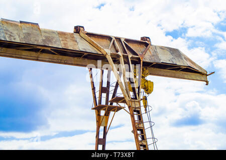 Vecchio arrugginito gantry crane sul cielo blu sullo sfondo. Foto Stock